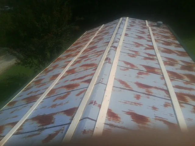 Rusted metal roof panels with new wood purlins before replacement — Storm Damage Roof Repair in Bunn by Roofing Brothers